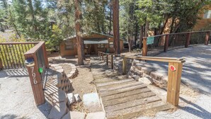 A wooden staircase leading to a cabin surrounded by trees. - True Big Bear Lake Cabin with jacuzzi (Big Bear Lake)