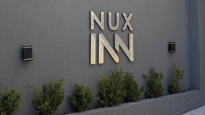 Un edificio con un letrero que dice "NUX INN" en una pared gris.