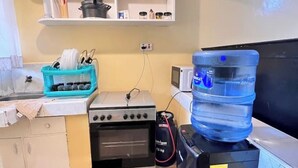 A kitchen with a stove, oven, and a water dispenser. - Rossyln haven studio (Nairobi)