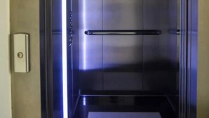An elevator with a metallic interior, a handrail, and a door with a handle. - Puerto Pileta Grill and Garage on the Peninsula (Punta del Este)