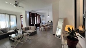 Un salon moderne comprenant un canapé, une table basse et un coin repas avec une table et des chaises.