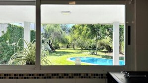 A kitchen with a view of a backyard that includes a swimming pool and lush greenery. - Beautiful Quinta House for 12 people very spacious (Entre Ríos)