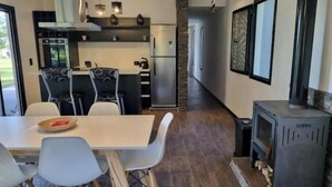 Una cocina moderna con comedor, chimenea y vistas al exterior.
