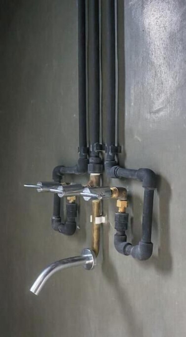 Instalación de fontanería con varias tuberías y un grifo.