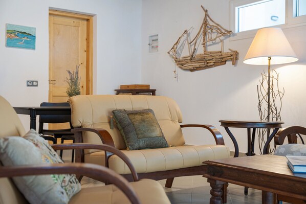 Un salon avec un canapé beige, une table basse en bois et une lampe.
