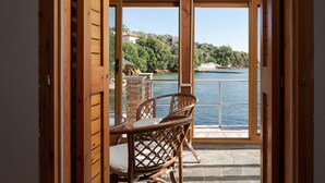 A wooden interior with a view of a lake and boats. - Porto Castello Villas (Skiathos)