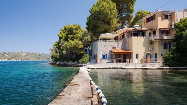 A coastal building with a balcony, a stone pathway leading to the water, and a clear view of the sea. - Porto Castello Villas (Skiathos)
