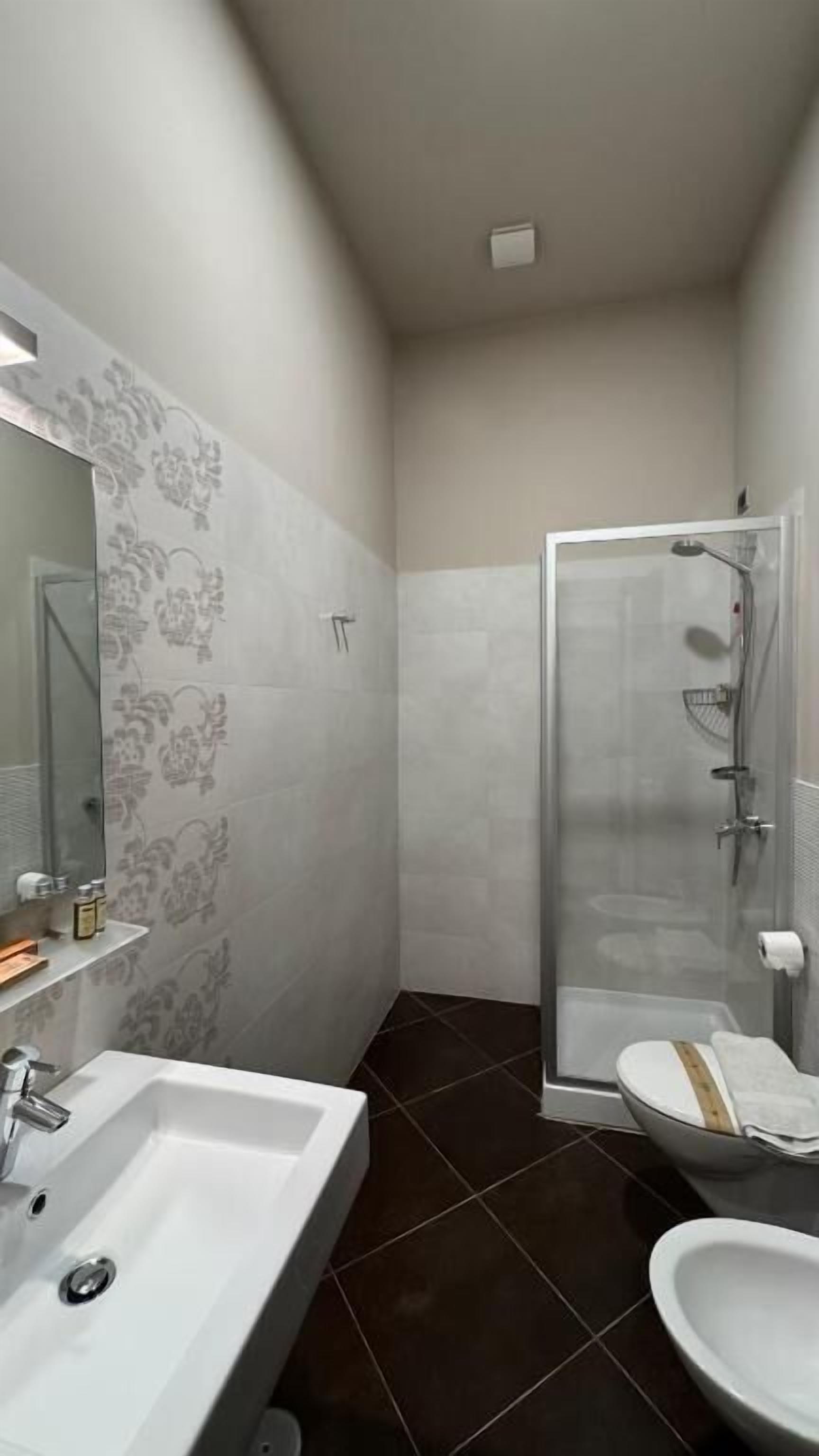 A bathroom with a shower, sink, and toilet.