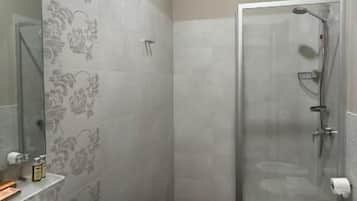 A bathroom with a shower, sink, and toilet.