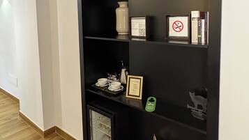 Eine schwarze Regaleinheit mit verschiedenen Gegenständen, darunter eine Vase, ein gerahmtes Zertifikat und ein Rauchverbot-Schild.