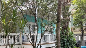 Un jardin luxuriant, agrémenté de diverses plantes et délimité par une clôture blanche.