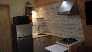 A compact kitchen with a built-in microwave, a sink, and a gas stove. - aframe in the woods. (Emsdale)