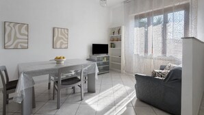 Un espace repas comprenant une table, des chaises, un téléviseur et un canapé.