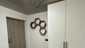 A room with a wardrobe, a door, and a wall-mounted hexagonal decoration. - Loft studio apartment (Envigado)