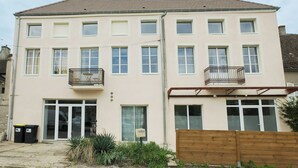 Un edificio de dos plantas con techo plano, varias ventanas y balcones.