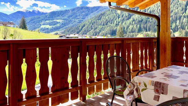 A wooden deck with a table and chairs, overlooking a mountainous landscape. - Apartment 'Sunny' with Mountain View, Shared Pool and Wi-Fi (Ratschings - Mareit)
