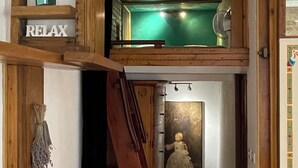 A multi-level interior with a wooden staircase, a fan, and a painting.