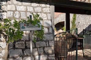 A reception sign with a mountain icon, a stone wall, and a metal gate.