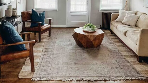 Una sala de estar con una mesa de centro de madera, dos sofás y un televisor sobre un soporte.