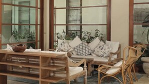 A spacious room with a high ceiling, large windows, and a wooden bench. - Tranquil three bedrooms villa forest view in Jimbaran (Bali)