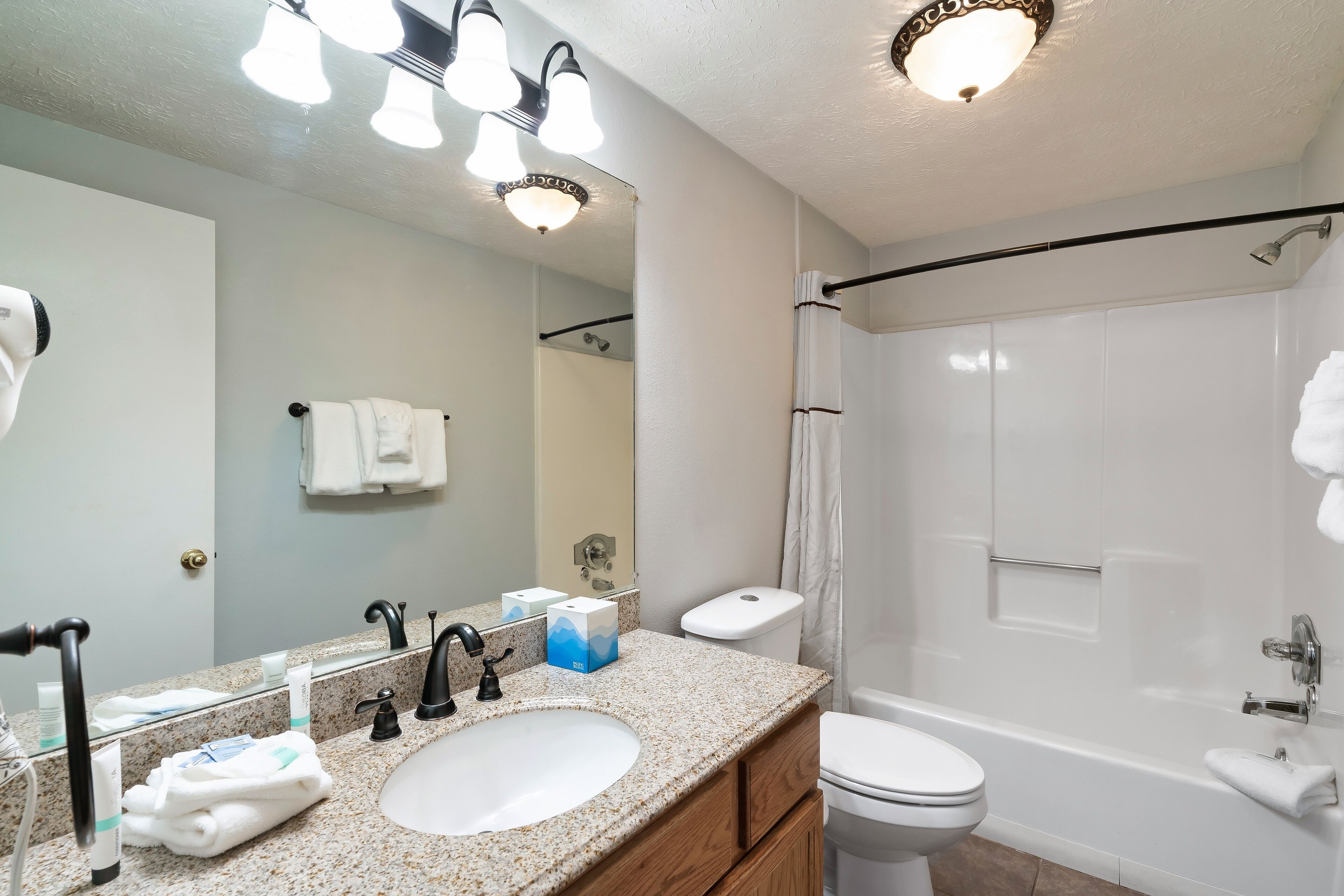 A modern bathroom with a sink, mirror, and shower.