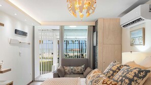 Een moderne slaapkamer met een bed, een slaapbank en een balkon met uitzicht.