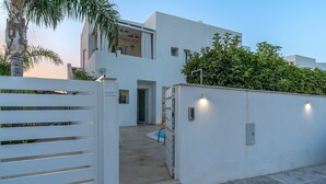 A modern building with a white exterior, a gated entrance, and a pool area. - Apartment 'Falso Pepe Marzamemi' with Private Pool, Private Terrace and Air Conditioning (Marzamemi)
