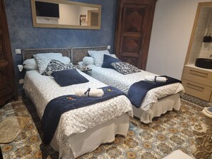 A double bed with a floral bedspread, a wooden headboard, and a bedside table with a lamp.