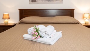 A neatly made bed with a brown bedspread, a headboard, and two bedside lamps. - Holiday Home 'Mari E Monti' with Sea View, Wi-Fi and Air Conditioning (Scano di Montiferro)