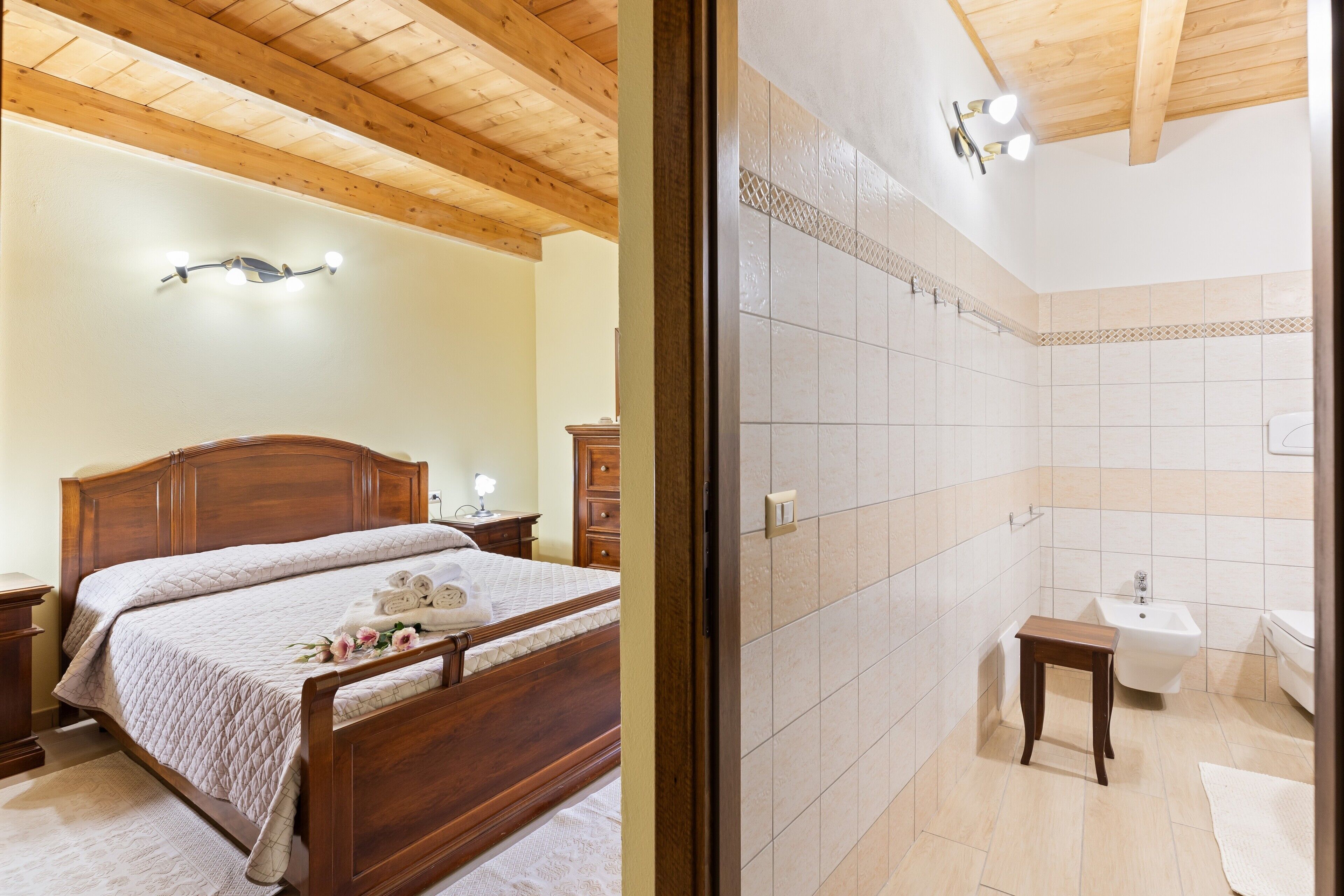 A bedroom with a wooden bed, bedside tables, and a nightstand.