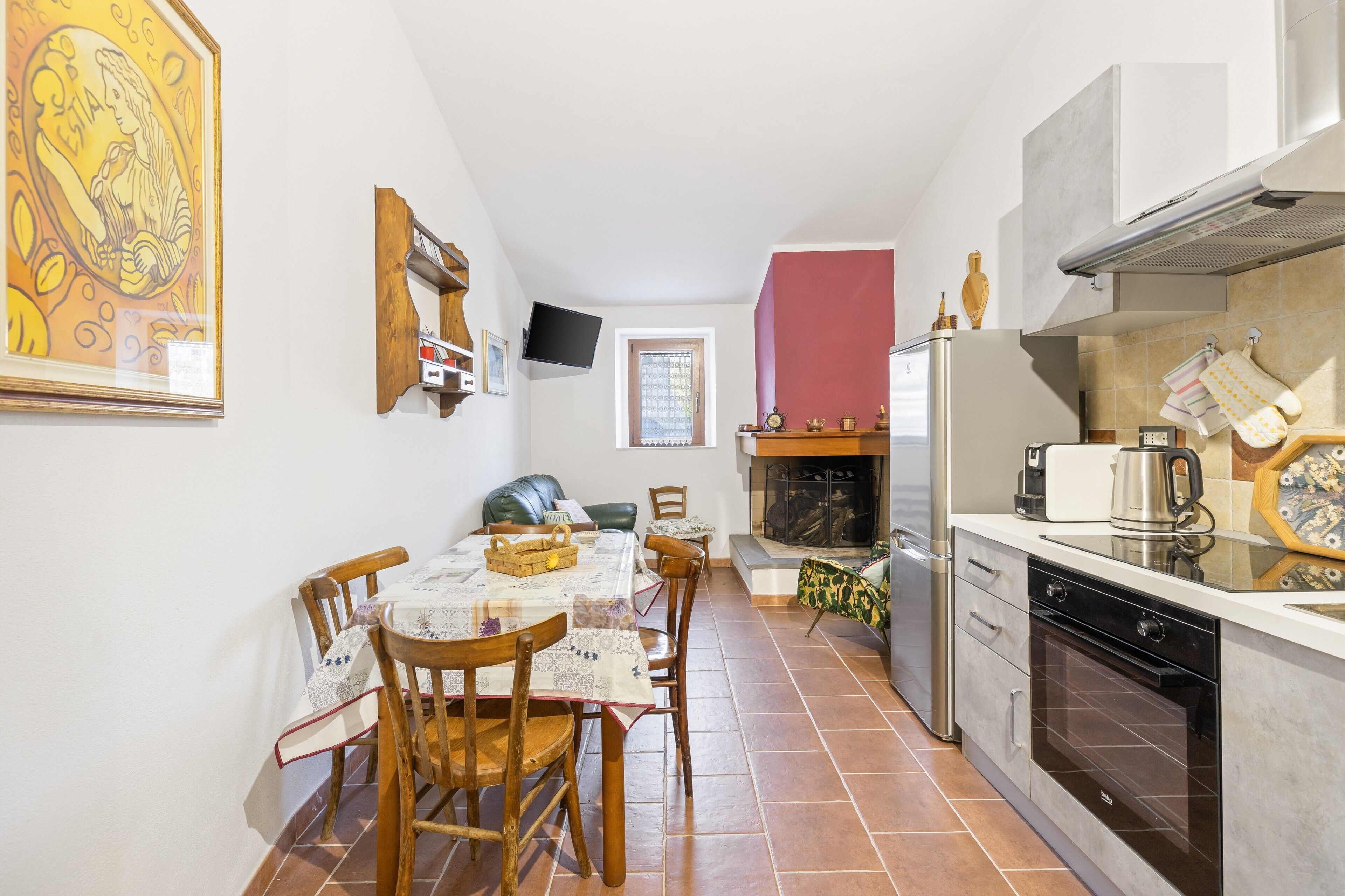 Eine kompakte Küche mit Essbereich, Kamin und Wandfernseher.