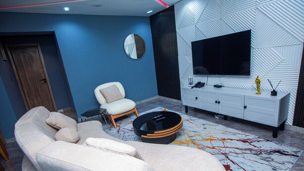 A modern living room with a sectional sofa, a coffee table, a TV, and a white cabinet.