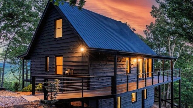 A wooden cabin with a balcony, a deck, and a large window on the front. - Panoramic Views! Wrap around Deck, Hot Tub & Grill (Morganton)