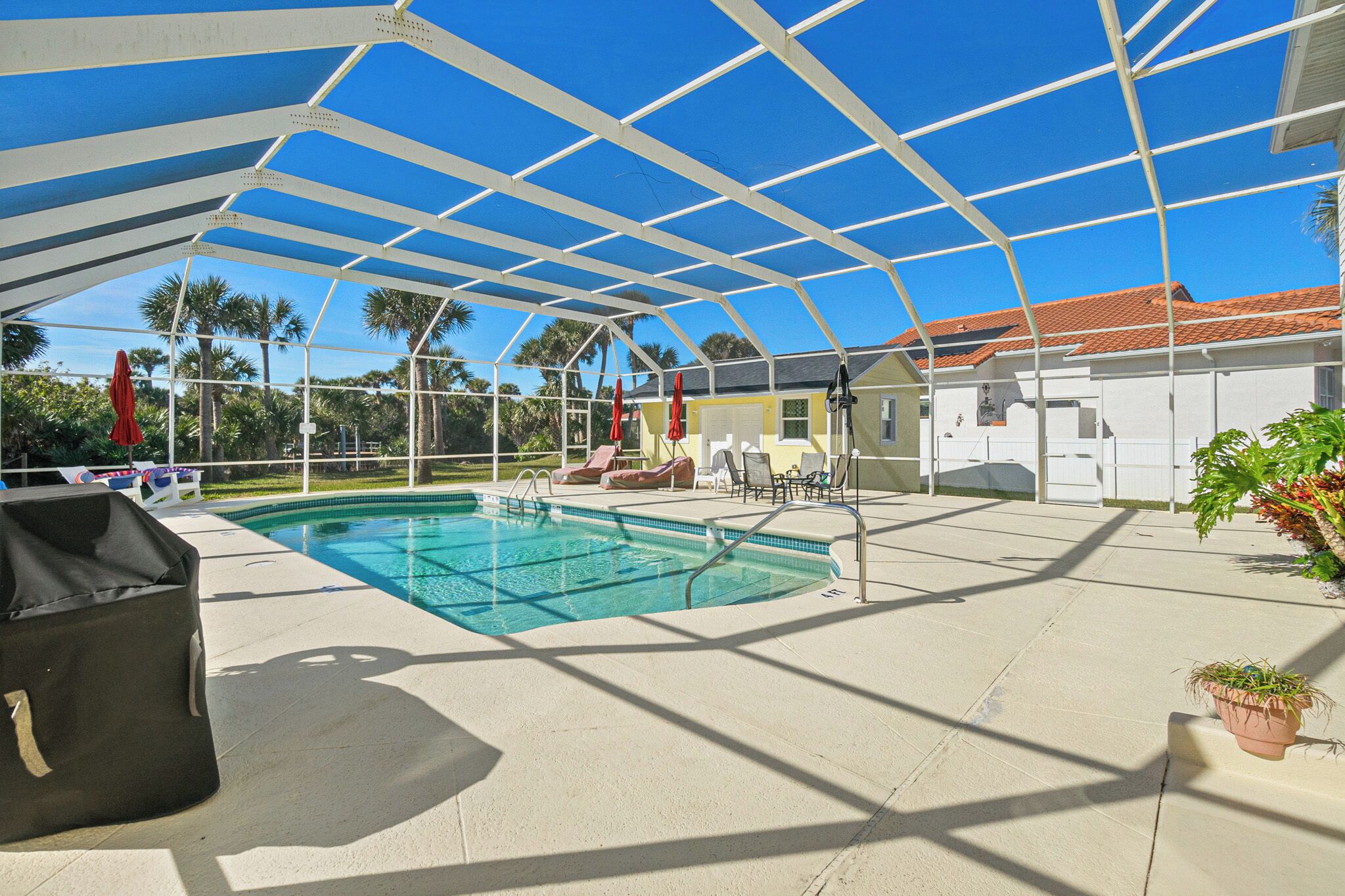 Una piscina al aire libre, sombrillas, sillones reclinables de piscina
