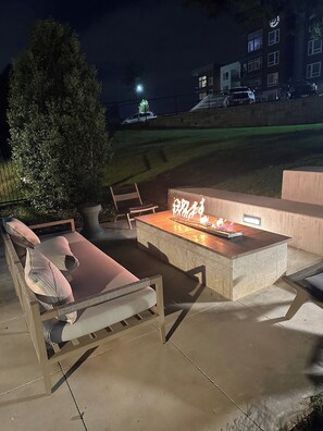 An outdoor seating area with a fire feature, a lounge chair, and a potted plant. - Peaceful North Austin Retreat Near The Domain (Austin)