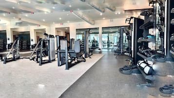 Ein modernes Fitnessstudio mit verschiedenen Trainingsgeräten, Spiegeln und einer sauberen, gut beleuchteten Atmosphäre.