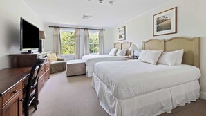 A hotel room with two beds, a TV, a desk, and a window with curtains. - Charming 2-Bedroom Ski-In/Ski-Out at Jackson Gore (Ludlow)