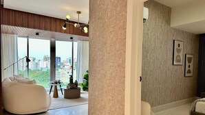 Un salon moderne avec une grande fenêtre, un canapé, une table basse et une lampe décorative.