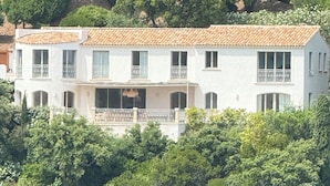 A two-story building with a tiled roof, multiple balconies, and a large central window. - New 5*star villa - Gulf of Saint-Tropez  - Beautiful sea view - (Cavalaire-sur-Mer)