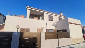 Een tweelaags huis met een hek, een balkon en een schotelantenne.