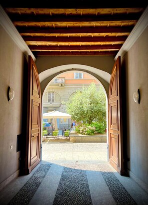 An arched doorway leading to an outdoor seating area with tables and chairs.