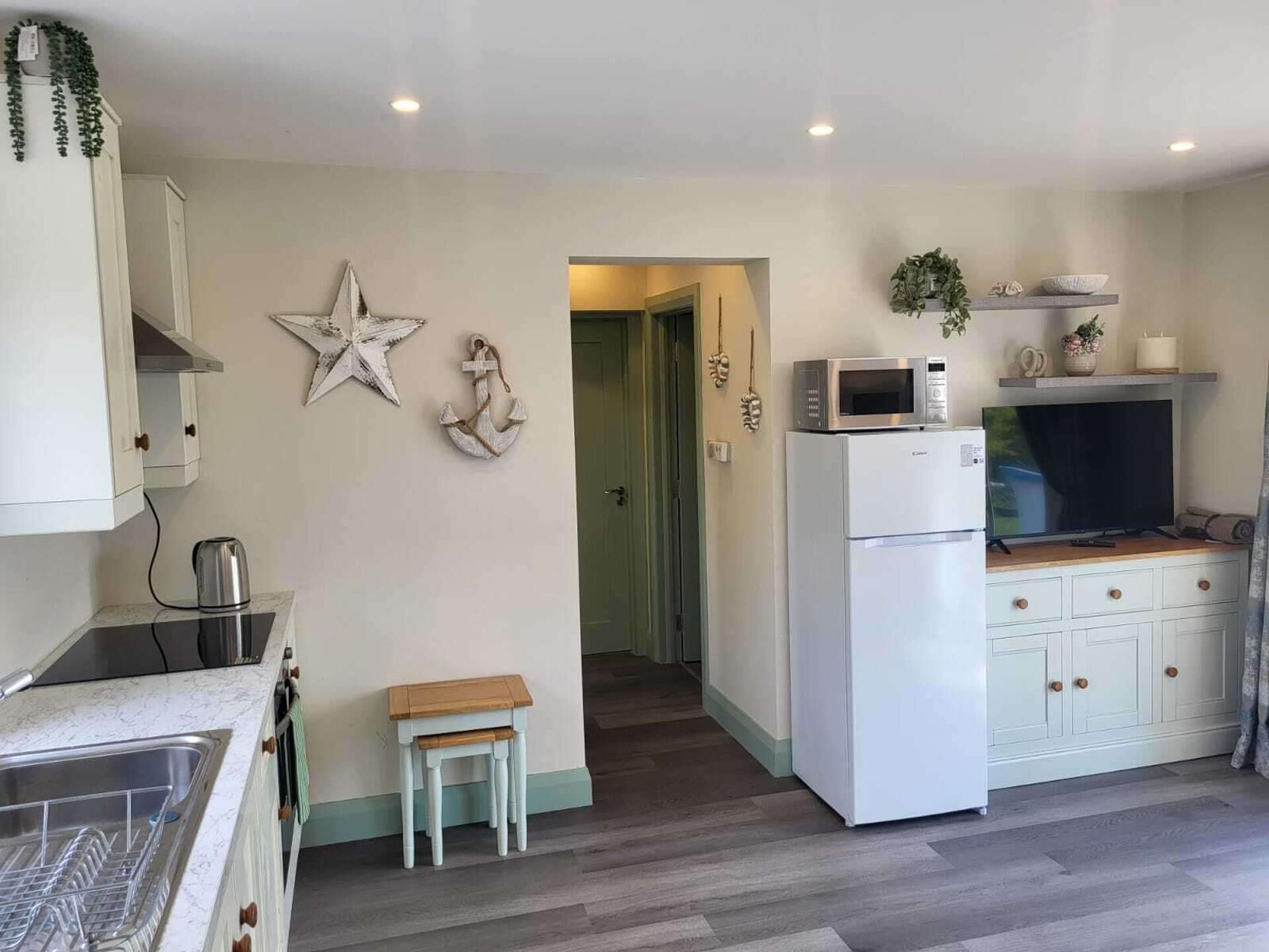A kitchen with a microwave, refrigerator, and wooden cabinets.