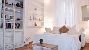 A bedroom with a bed, bedside tables, a nightstand, a bookshelf, and a window with curtains. - LuMa Suite Spanish-Trevi Via degli Artisti 23 (Roma)