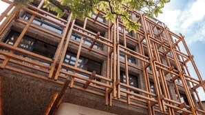A building with a wooden lattice facade and a sign reading 'PERGAMINO.'