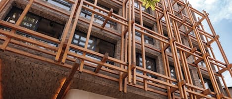 A building with a wooden lattice facade and a sign reading 'PERGAMINO.'