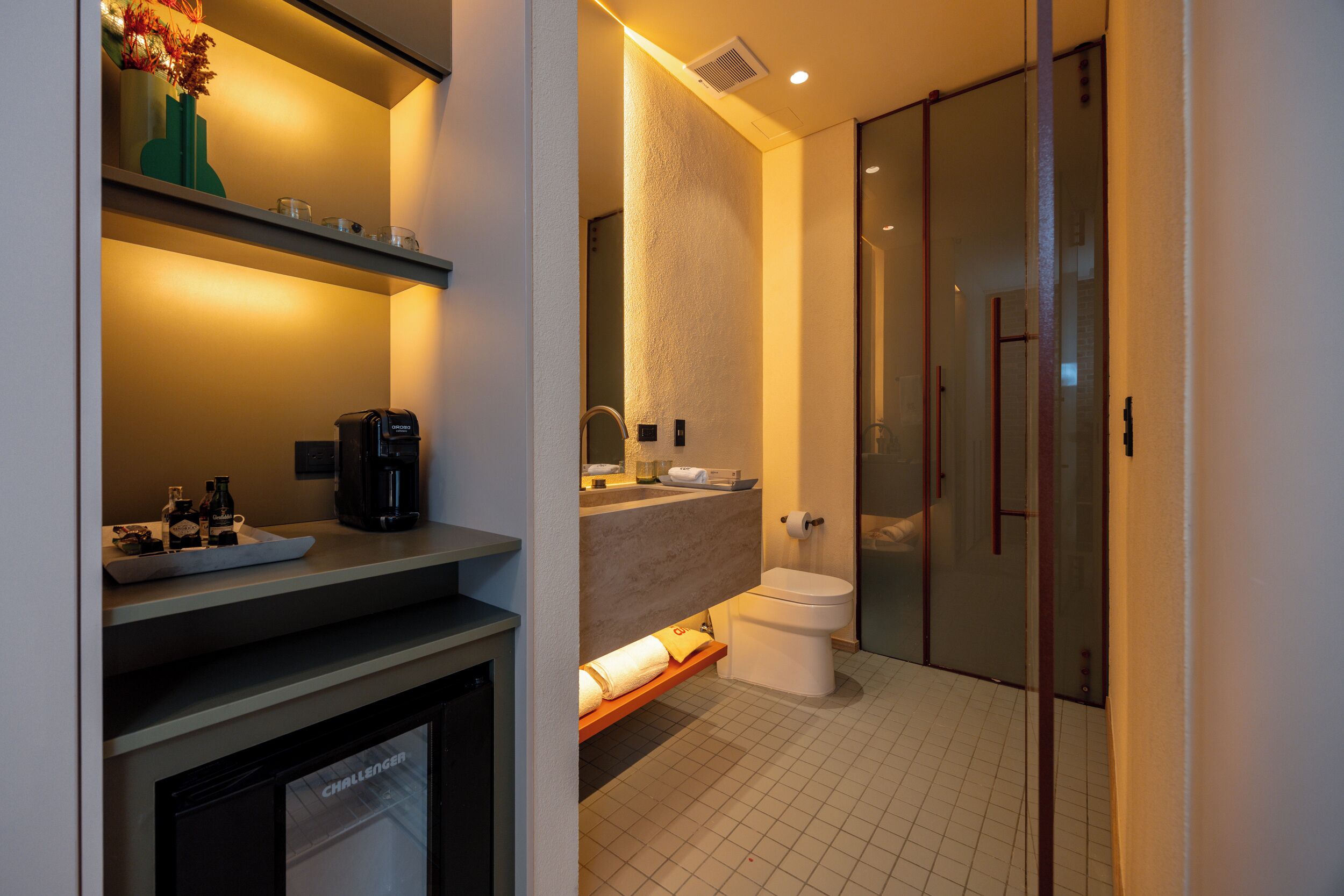 Un baño moderno con inodoro, lavabo y zona de ducha.