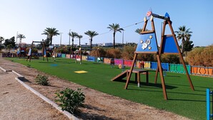 A playground with swings, slides, and a climbing structure. - Apartment in Vera playa. Between Sol and Salinas (AN)