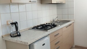 A kitchen with a gas stove, a coffee maker, and a dishwasher.