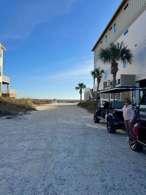 A coastal road with a building on the right and a dune in the distance. - Mari Muria Beach House (Orange Beach)