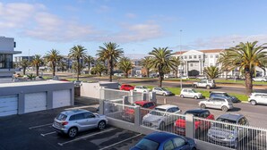 Un parcheggio con diverse auto e un edificio sullo sfondo.